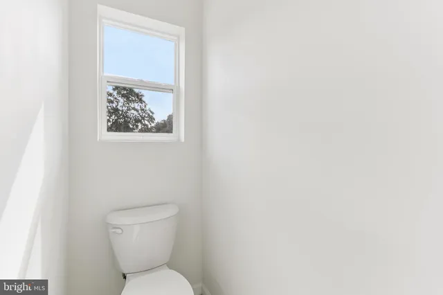 a view of a white house in a yard with potted plants