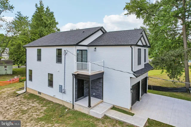 an aerial view of residential houses with outdoor space and trees