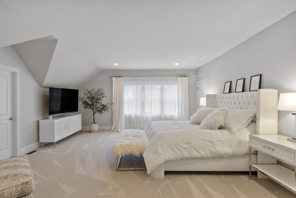 77 Revolutionary Road Concord, MA 01742 - Photo 17 of 42 a spacious bedroom with a large bed and a flat screen tv