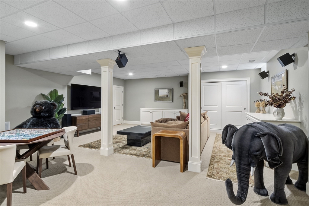 77 Revolutionary Road Concord, MA 01742 - Photo 33 of 42 a living room with furniture a chandelier and a flat screen tv