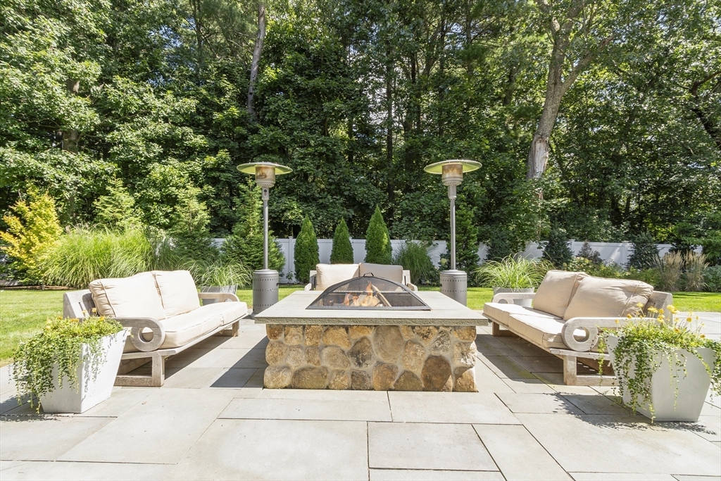 77 Revolutionary Road Concord, MA 01742 - Photo 39 of 42 a view of a patio with couches table and chairs and potted plants