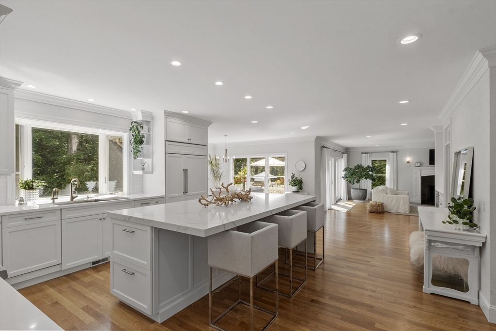 77 Revolutionary Road Concord, MA 01742 - Photo 9 of 42 a kitchen with a dining table chairs cabinets wooden floor and appliances