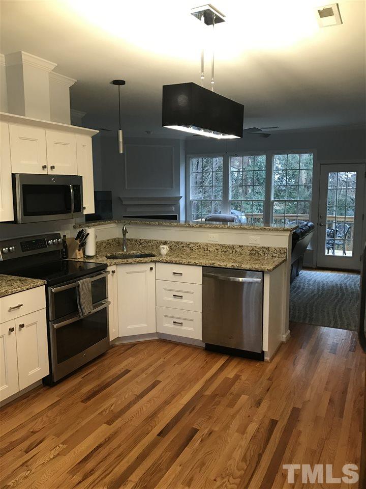 2136 Bellaire Avenue Raleigh, NC 27608 - Photo 3 of 6 a kitchen with stainless steel appliances granite countertop a stove a sink and a microwave