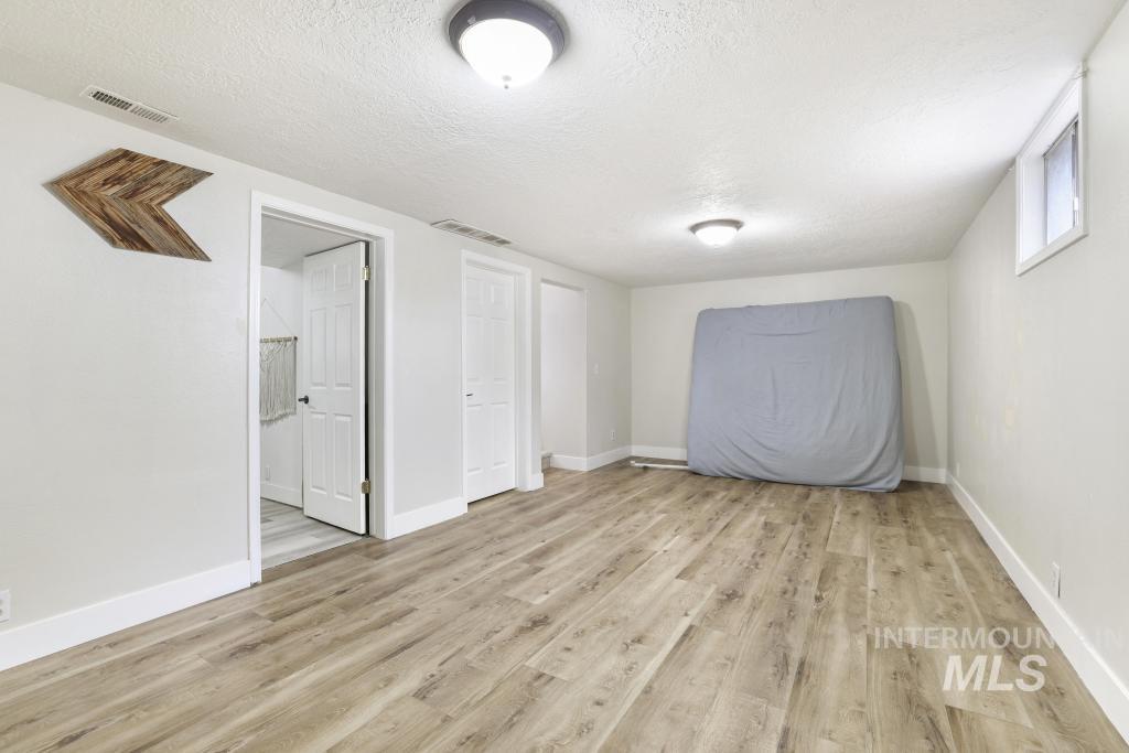 2243 4000 North Filer, ID 83328 - Photo 12 of 30 Unfurnished great room featuring light wood-style floors and a textured ceiling.