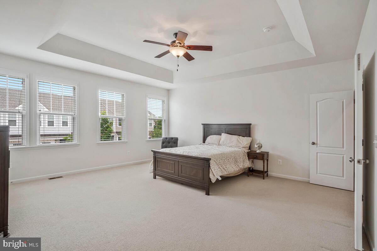 42523 Benfold Square Brambleton, VA 20148 - Photo 11 of 29 a spacious bedroom with a large bed and a chandelier