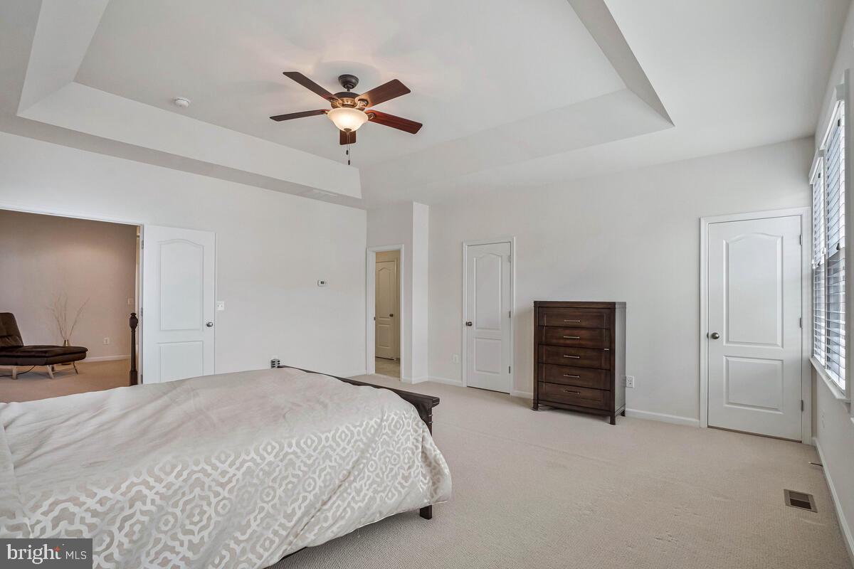 42523 Benfold Square Brambleton, VA 20148 - Photo 12 of 29 a bedroom with a large bed and a chandelier fan