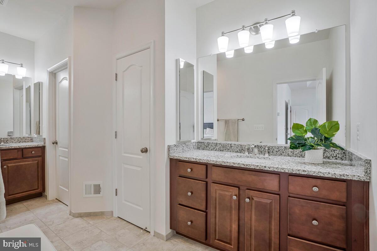 42523 Benfold Square Brambleton, VA 20148 - Photo 13 of 29 a bathroom with a granite countertop double vanity sink and mirror