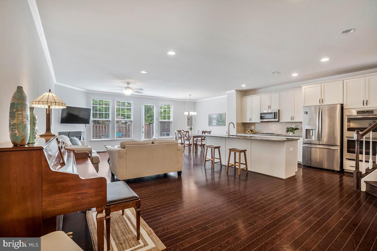 42523 Benfold Square Brambleton, VA 20148 - Photo 16 of 29 a living room with stainless steel appliances kitchen island granite countertop wooden floor a dining table and chairs