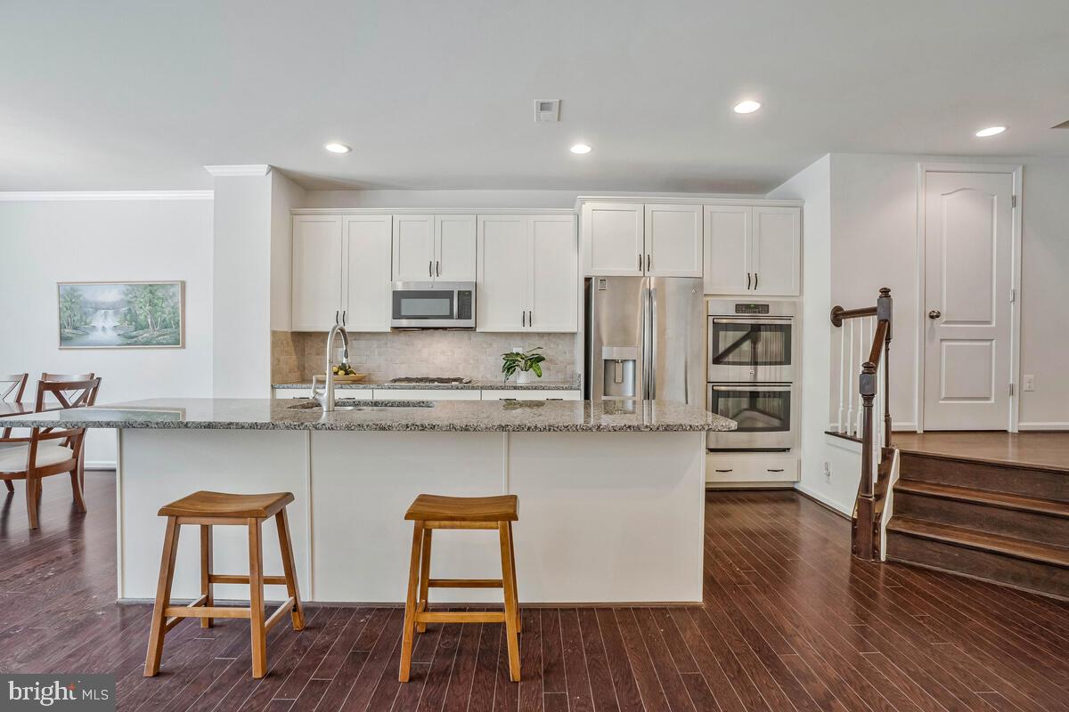 42523 Benfold Square Brambleton, VA 20148 - Photo 20 of 29 a kitchen with stainless steel appliances a stove a sink a refrigerator and cabinets