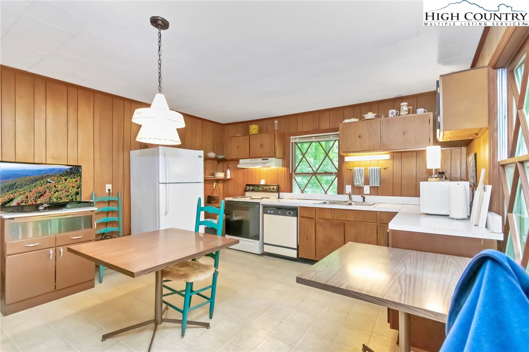 206 Oak Road Beech Mountain, NC 28604 - Photo 11 of 35 a kitchen with a refrigerator a stove a sink dishwasher with a dining table and chairs