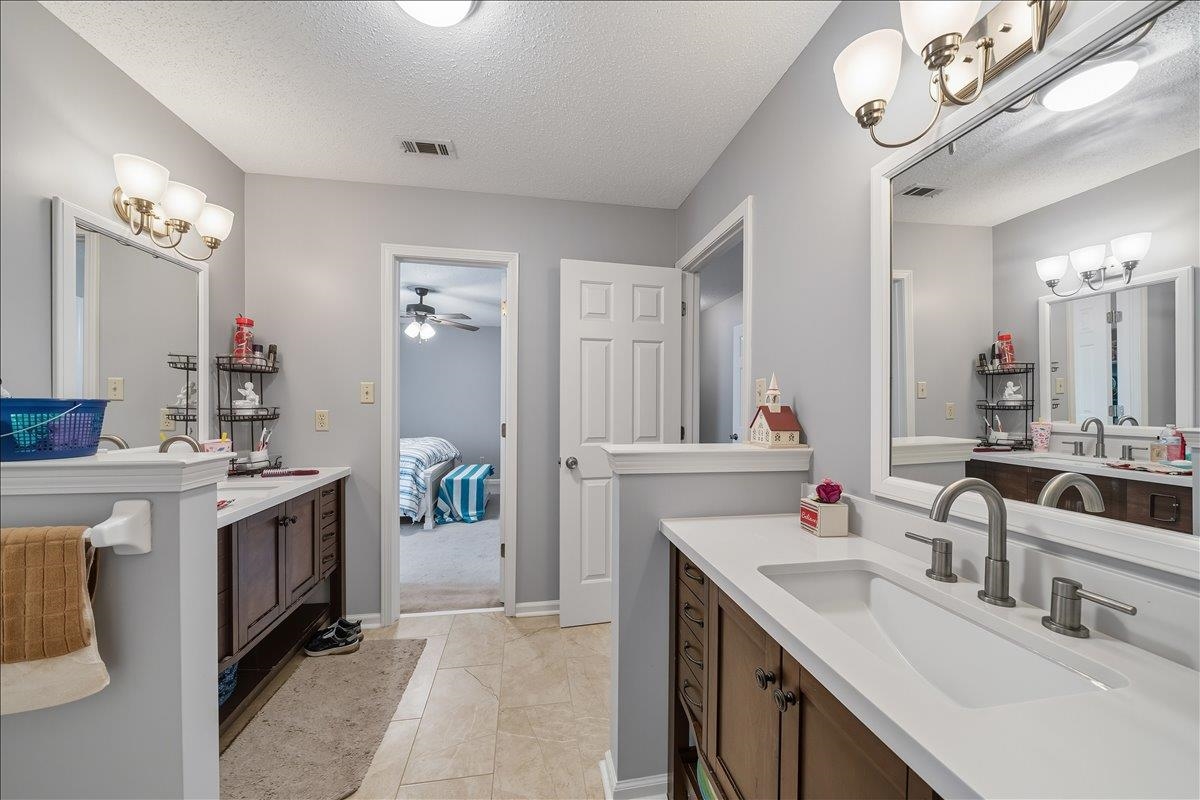6870 Deerfield Road Bartlett, TN 38135 - Photo 17 of 28 Ensuite bathroom featuring two vanities, a textured ceiling, ceiling fan, and hanging lights