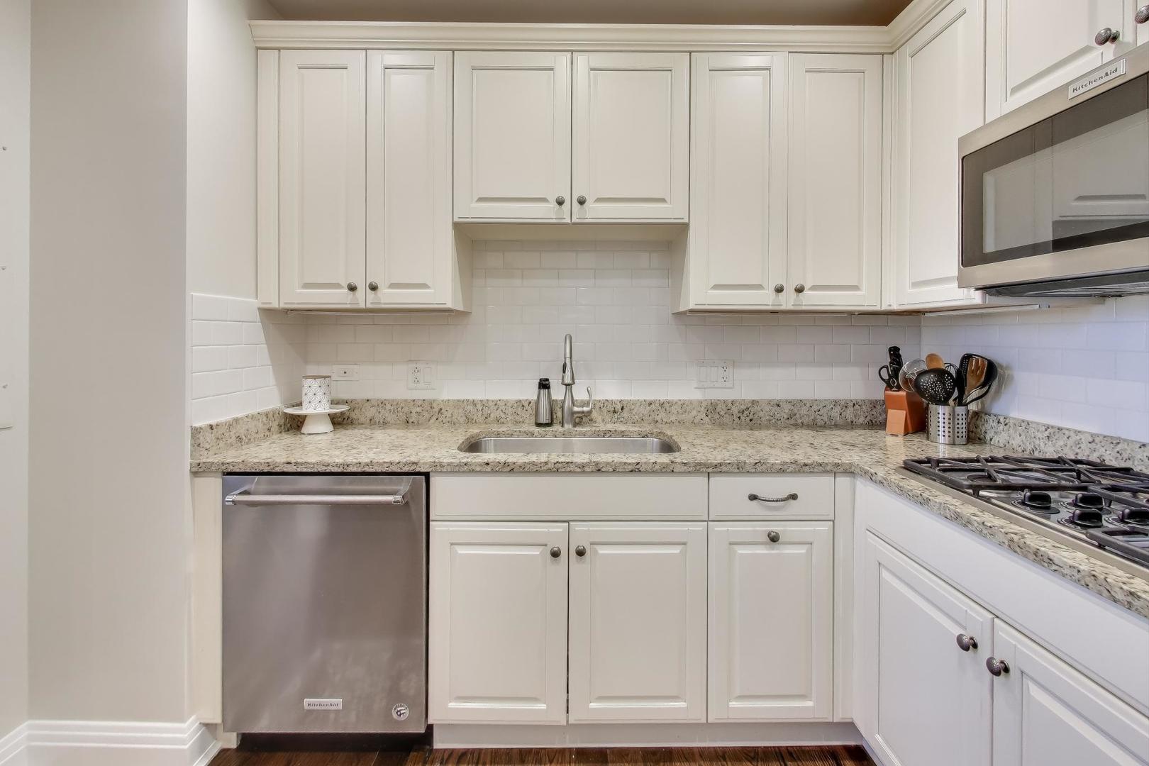 1041 Ridge Road, Unit 503 Wilmette, IL 60091 - Photo 10 of 22 a kitchen with granite countertop white cabinets and stainless steel appliances