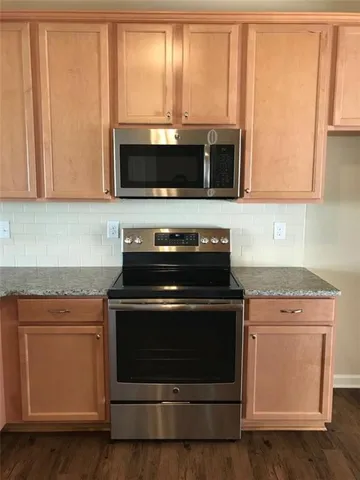 a stove top oven sitting inside of a kitchen