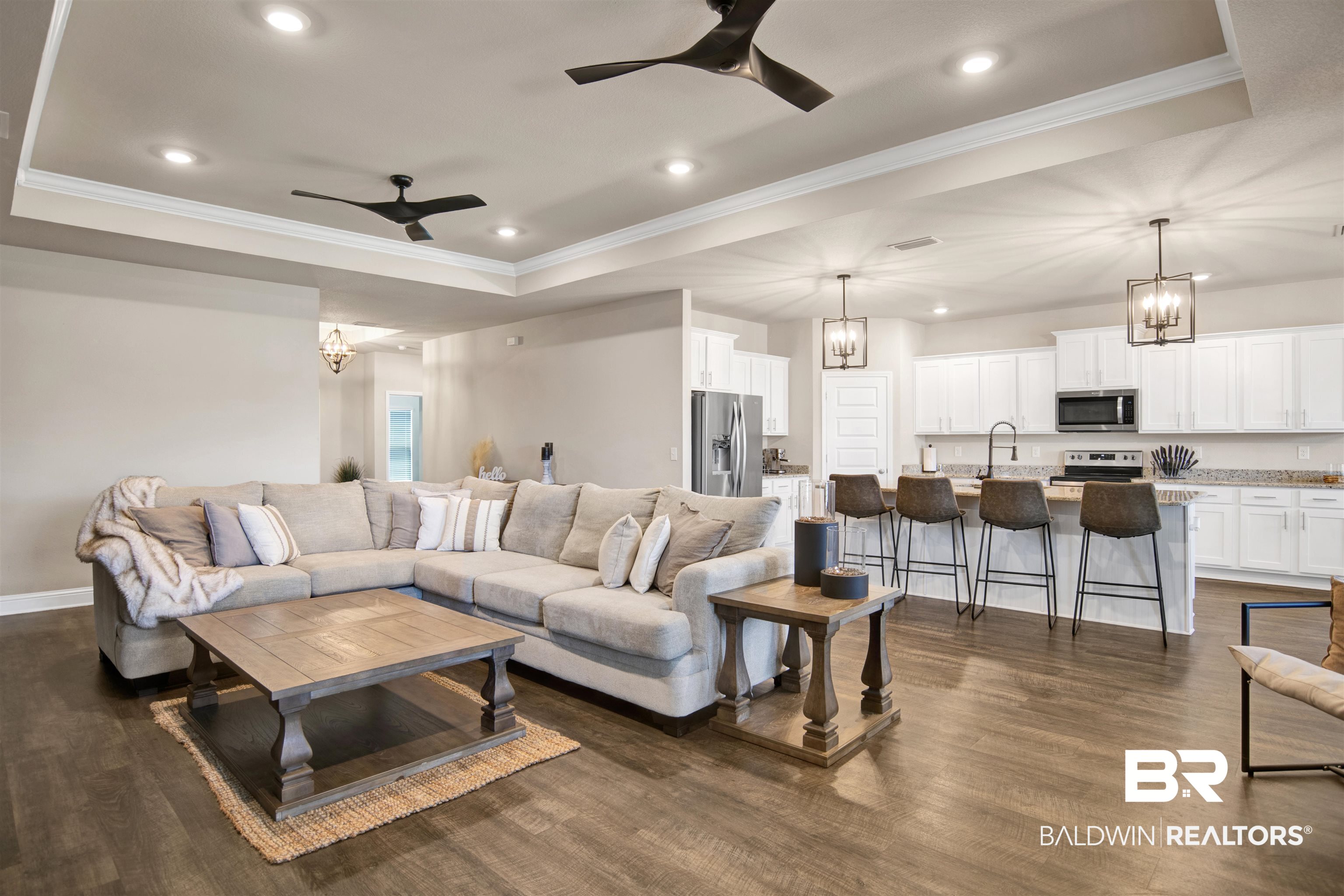 8493 Bronze Lane Foley, AL 36535 - Photo 10 of 38 Open-concept living area featuring wood-finish flooring, recessed lighting, and tray ceilings