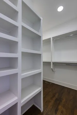 a view of walk in closet with empty racks