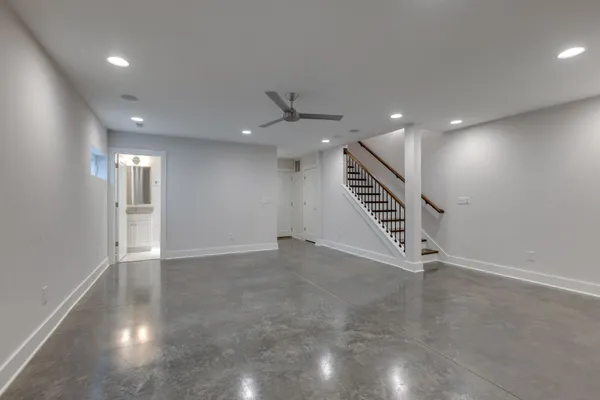 an empty room with wooden floor entryway and windows