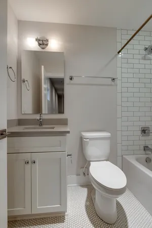 a bathroom with a toilet a sink and mirror