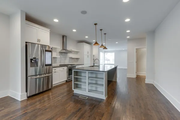a kitchen with kitchen island white cabinets and stainless steel appliances