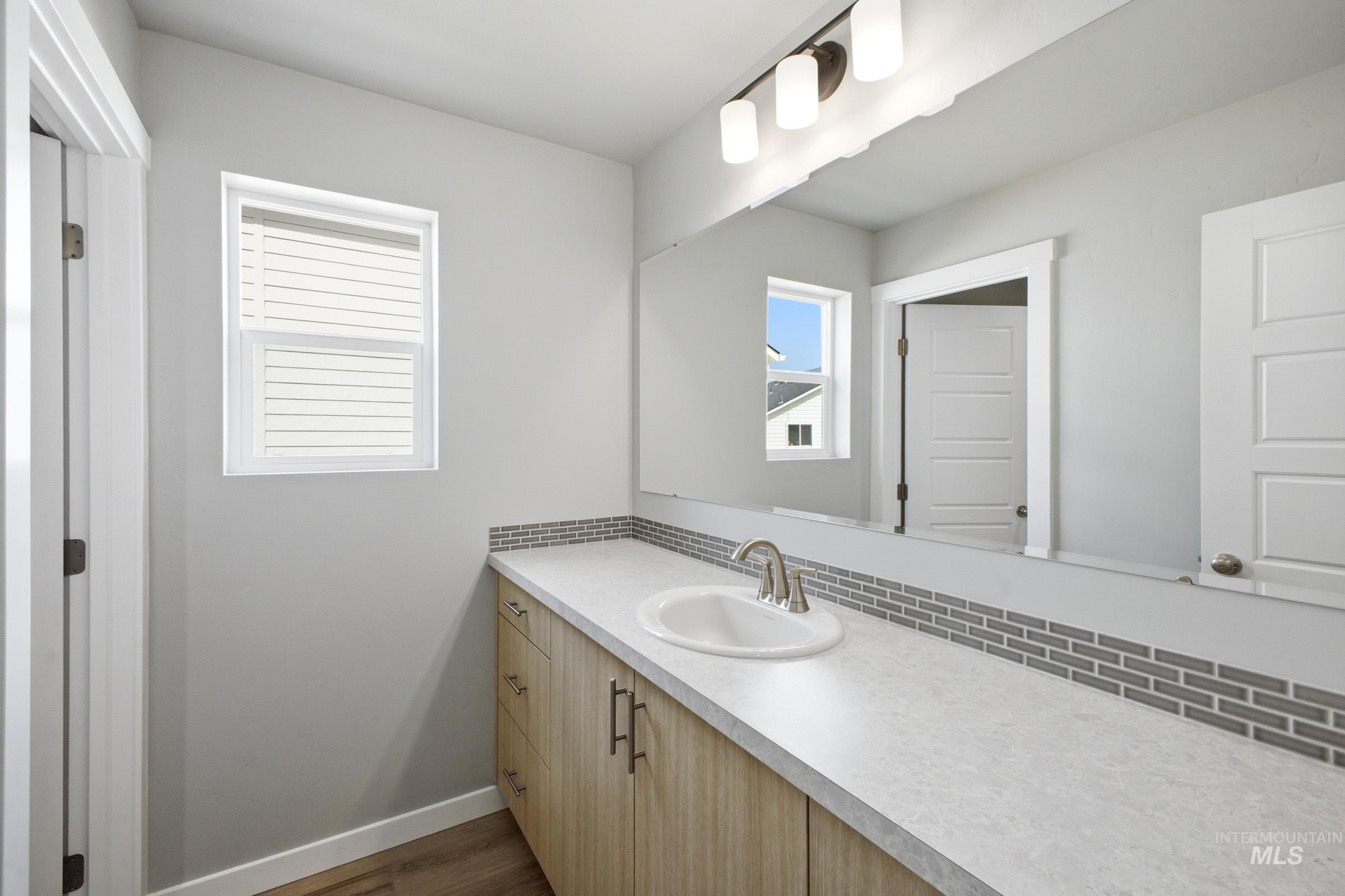 5315 South Memory Avenue Meridian, ID 83642 - Photo 15 of 24 Bathroom featuring vanity, tasteful backsplash, and dark wood-style flooring