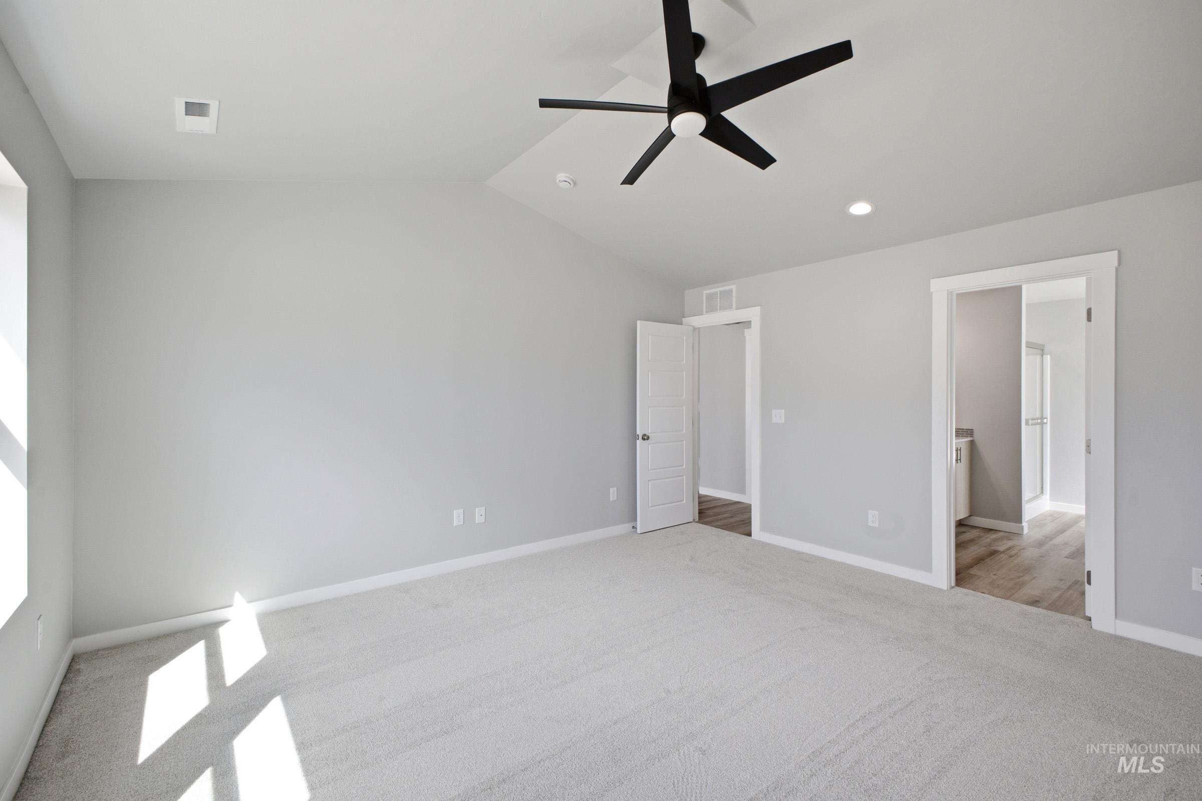 5315 South Memory Avenue Meridian, ID 83642 - Photo 20 of 24 Unfurnished bedroom featuring lofted ceiling, light colored carpet, ceiling fan, and ensuite bathroom