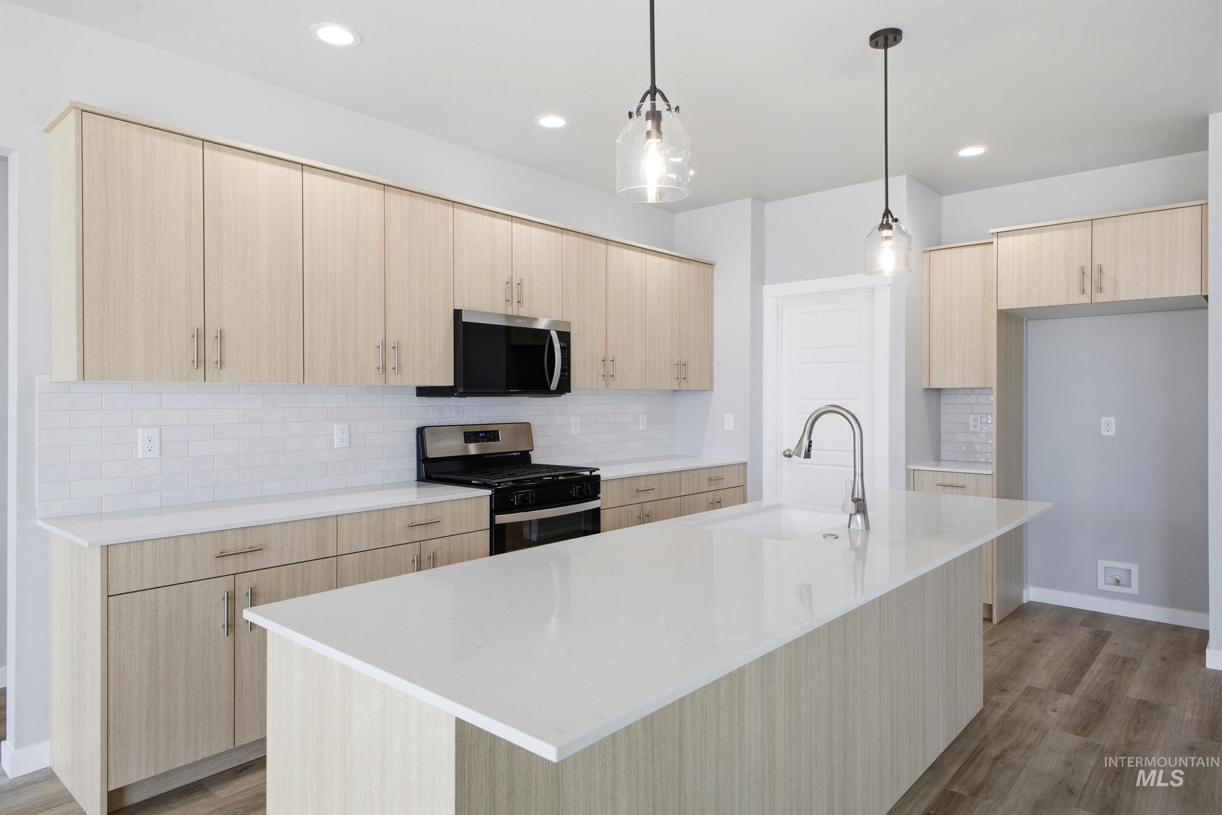 5315 South Memory Avenue Meridian, ID 83642 - Photo 4 of 24 Kitchen featuring light wood finish cabinets, stainless steel appliances, decorative backsplash, and light wood finished floors