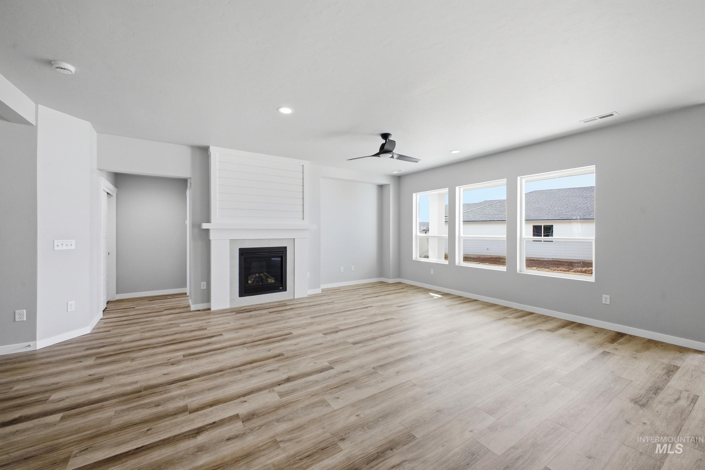 5315 South Memory Avenue Meridian, ID 83642 - Photo 8 of 24 Unfurnished living room featuring ceiling fan, a fireplace, light wood-type flooring, and recessed lighting