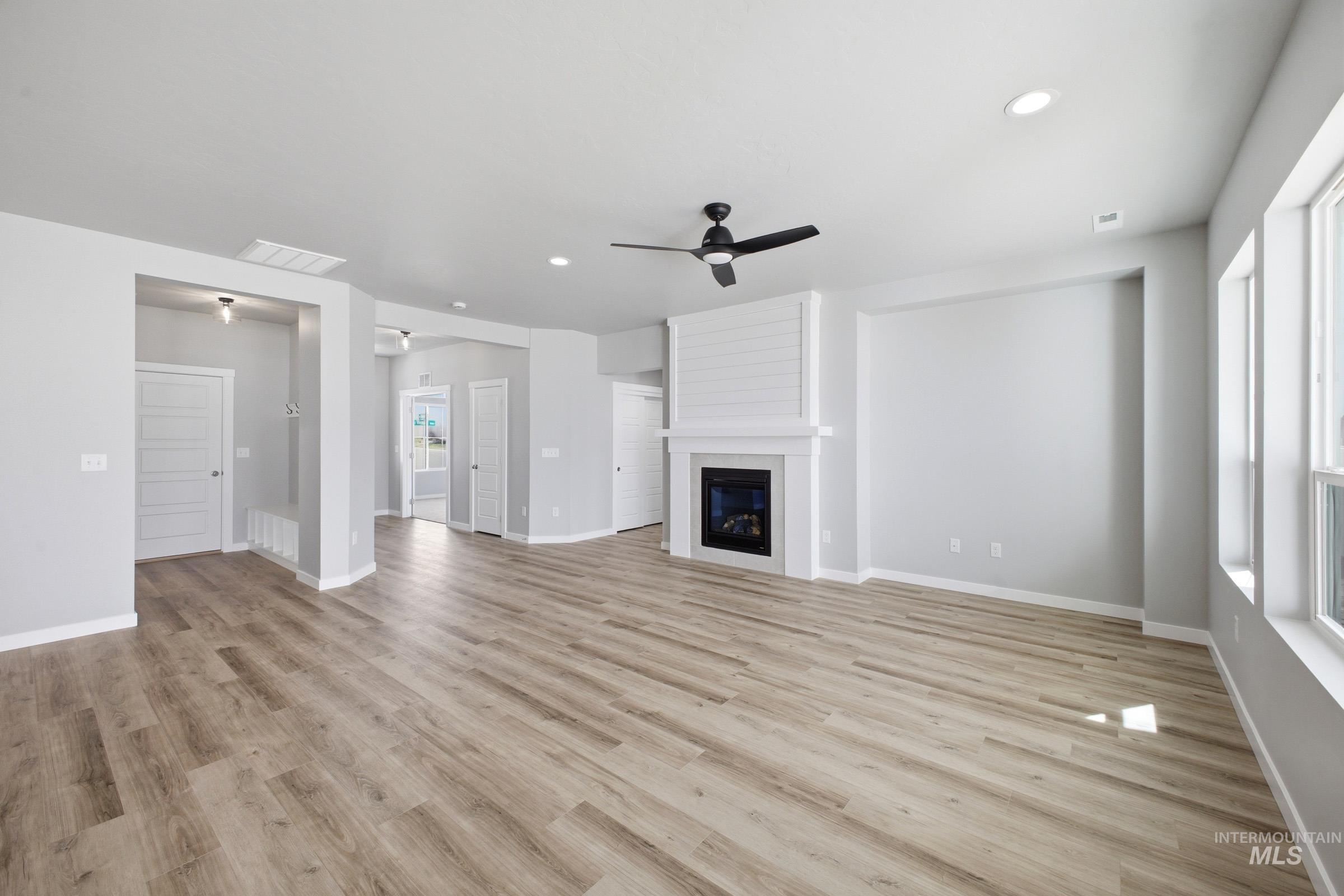 5315 South Memory Avenue Meridian, ID 83642 - Photo 9 of 24 Unfurnished living room featuring ceiling fan, a fireplace, recessed lighting, and light wood-style flooring