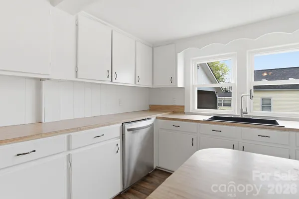 a kitchen with white cabinets and sink