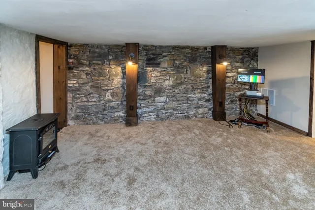a view of an empty room with a fireplace and a window