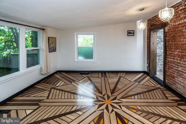 a view of a room with wooden floor and windows