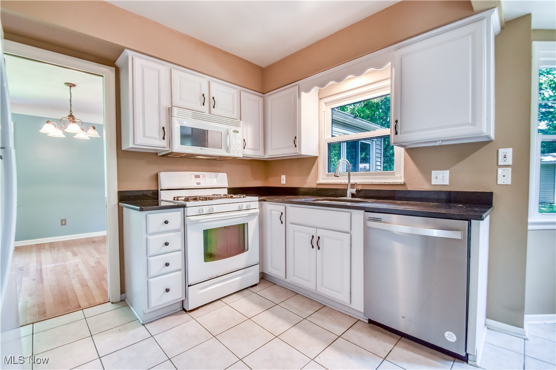 2607 Ashurst Road University Heights, OH 44118 - Photo 23 of 39 Kitchen featuring white appliances, dark countertops, white cabinets, and a chandelier