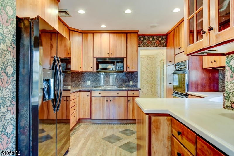 15 Overlook Road Caldwell, NJ 07006 - Photo 17 of 37 a kitchen with stainless steel appliances granite countertop a refrigerator a stove and a sink with wooden cabinets