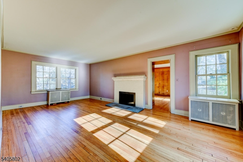 15 Overlook Road Caldwell, NJ 07006 - Photo 6 of 37 an empty room with windows fireplace and wooden floor