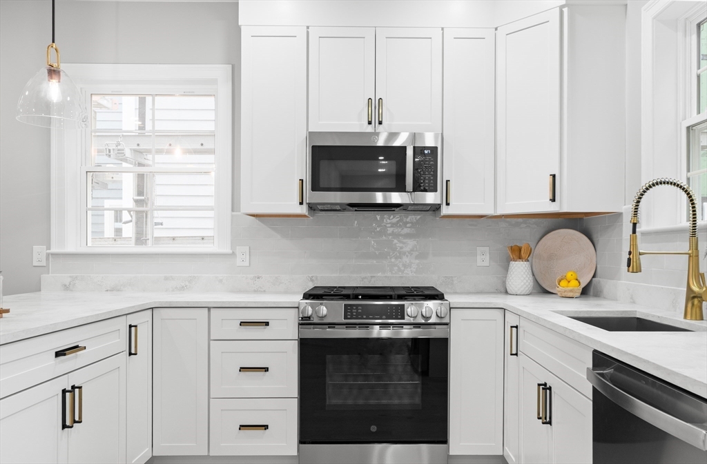 11-9 Washington Street, Unit NINE Ipswich, MA 01938 - Photo 10 of 33 a kitchen with stainless steel appliances white cabinets and a stove