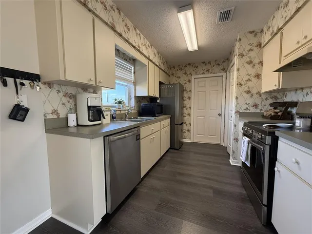 a kitchen with a sink cabinets and wooden floor