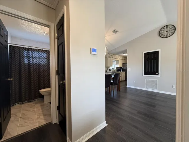 a view of house with backyard and trees in the background