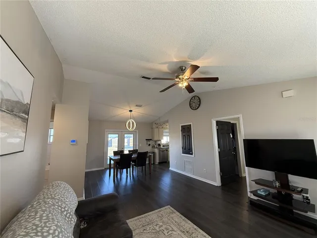 a view of a living room with hardwood floor and a ceiling fan