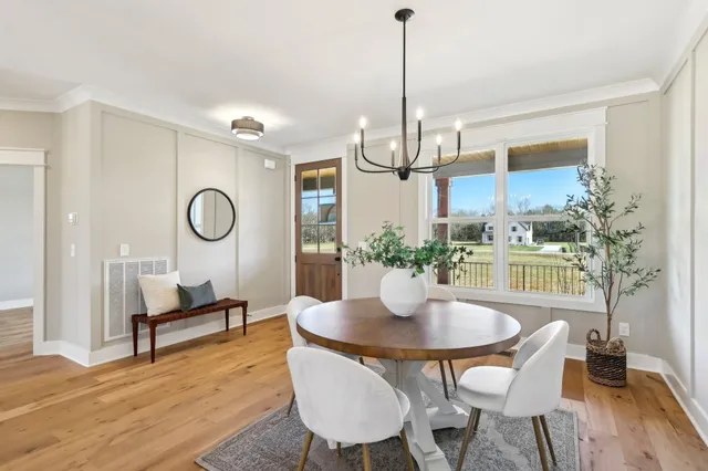 a kitchen with a stove a kitchen island a sink cabinets and chairs