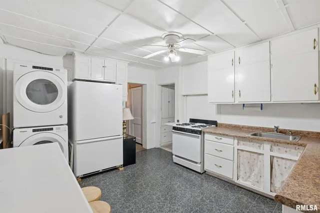 a kitchen with stainless steel appliances granite countertop a refrigerator a stove a sink and white cabinets