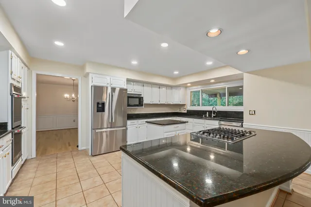 a kitchen with stainless steel appliances granite countertop a sink and a refrigerator