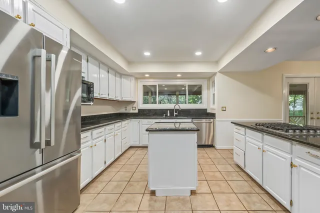 a kitchen with stainless steel appliances granite countertop a refrigerator sink and cabinets