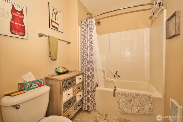 a bathroom with a sink a toilet and shower a mirror