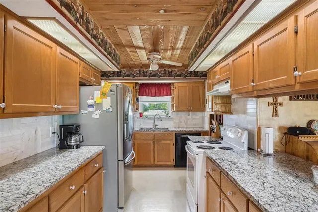 a kitchen with a stove sink and cabinets