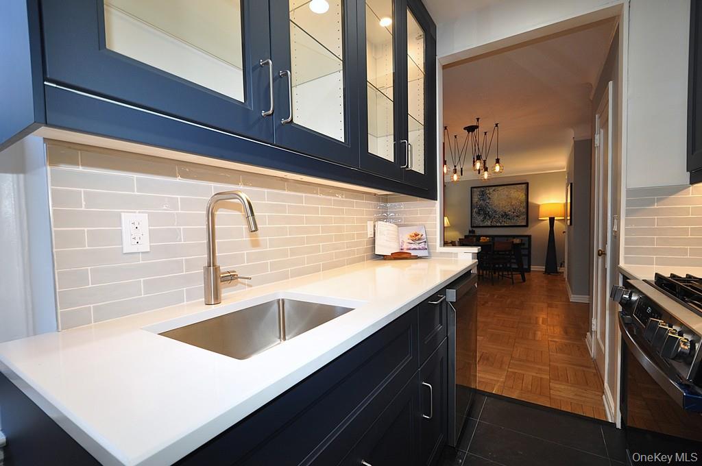 196 Garth Road, Unit 1G Scarsdale, NY 10583 - Photo 11 of 35 a kitchen with a sink a stove and cabinets