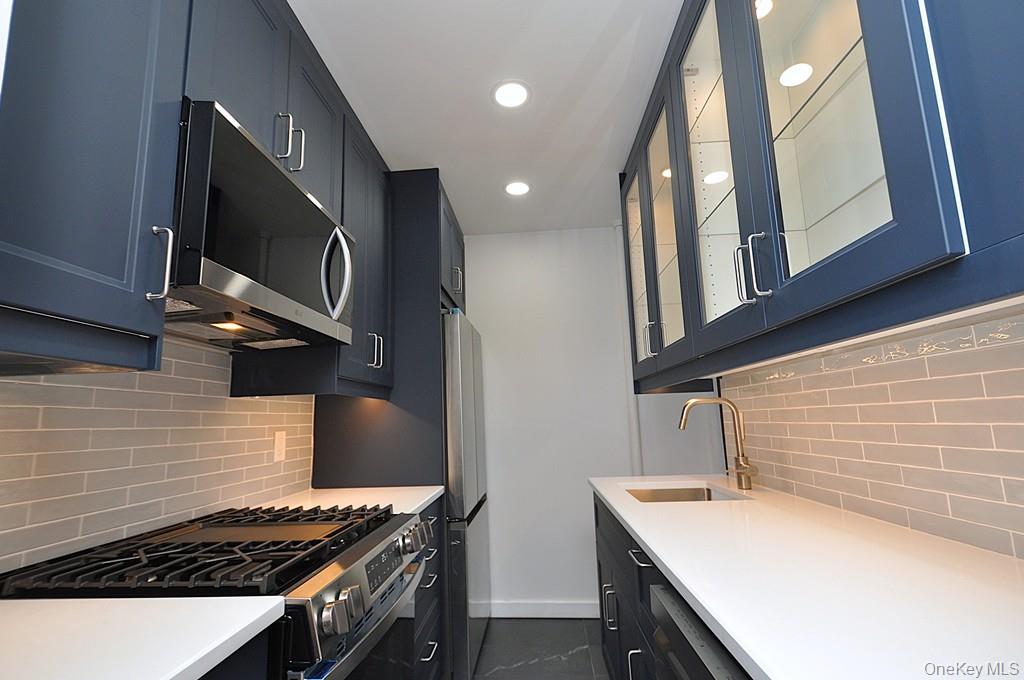 196 Garth Road, Unit 1G Scarsdale, NY 10583 - Photo 16 of 35 a kitchen with a stove and a microwave