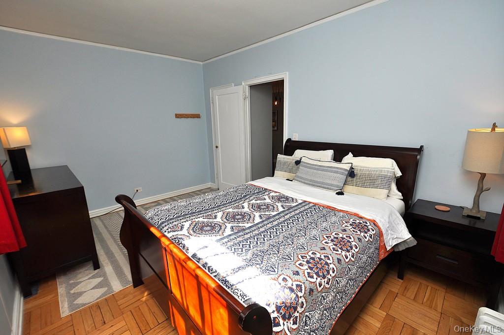 196 Garth Road, Unit 1G Scarsdale, NY 10583 - Photo 21 of 35 a bedroom with a bed and lamp on the dresser