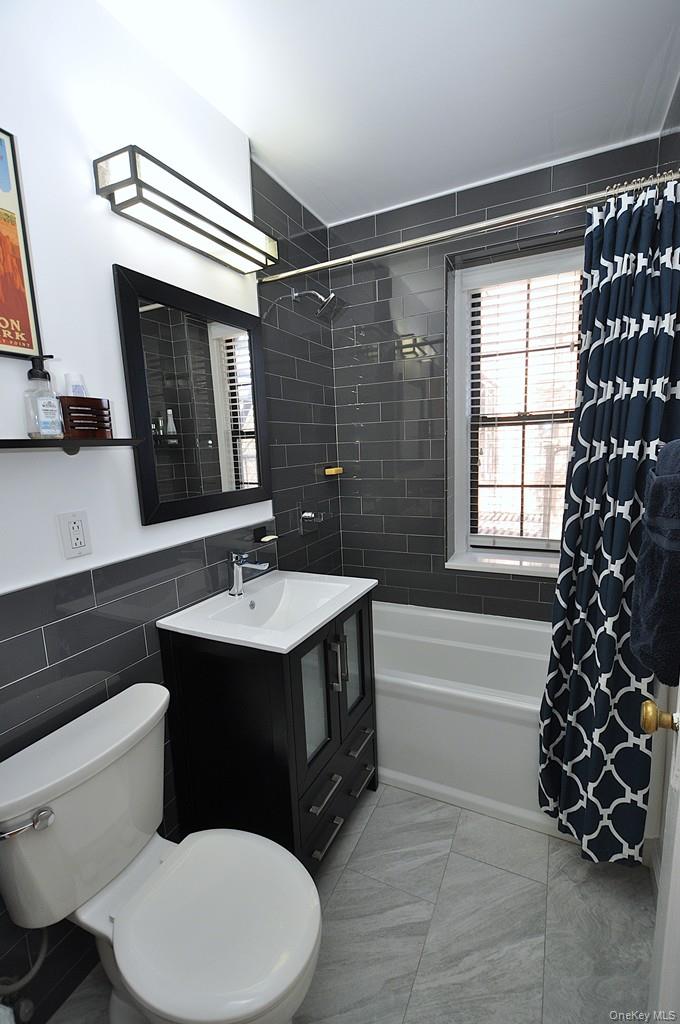 196 Garth Road, Unit 1G Scarsdale, NY 10583 - Photo 23 of 35 a bathroom with a sink toilet vanity and mirror