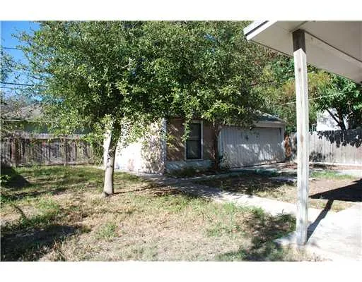 a backyard of a house with table and chairs