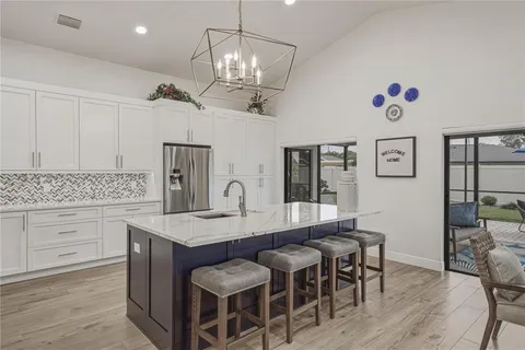 a kitchen with stainless steel appliances kitchen island granite countertop a stove and a wooden floors