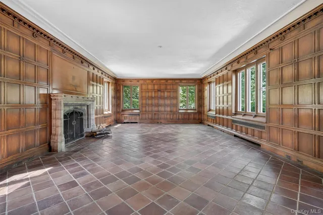 an empty room with a fireplace and window